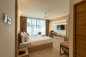 a hotel room with a bed and a desk and a desk at The Continental Suites in Kozhikode