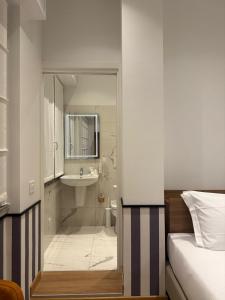 a bedroom with a bathroom with a shower and a sink at HÕMA Certosa District in Milan +50 photos