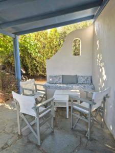 a patio with a table and chairs and a couch at Sea shell in Plaka