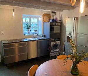 a kitchen with a sink and a refrigerator and a table at MAISON ST LAURENT in Olargues