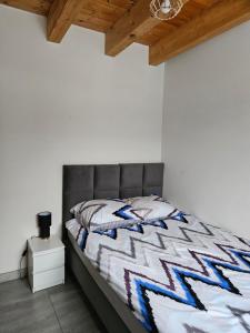 a bed with a gray headboard in a bedroom at Domek Bobrowe Zacisze 2 in Karpacz