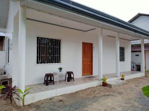 a white house with a table and two chairs at Meghan’s Homestay in General Luna
