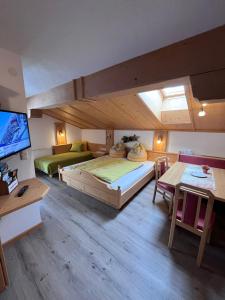 a large room with a large bed and a tv at Badmeisterhof in Leogang