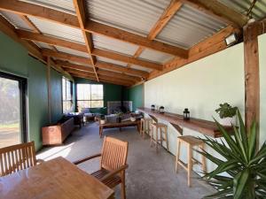 a living room with wooden ceilings and tables and chairs at Pebble Point in Princetown