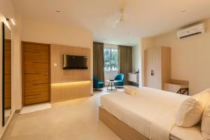 a hotel room with a bed and a television at The Continental Suites in Kozhikode