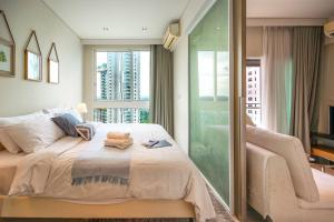 a bedroom with a bed and a large window at HighFloor Seaview Condo,Pool by the beach,Kitchen,Gym,WIFI in Jomtien Beach +38 photos