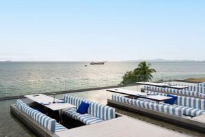 a resort with blue and white chairs and the ocean at HighFloor Seaview Condo,Pool by the beach,Kitchen,Gym,WIFI in Jomtien Beach