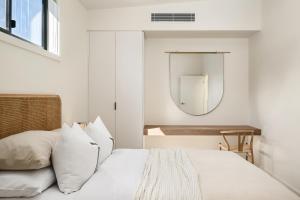 a bedroom with a white bed and a mirror at Apartment Two - Apartments on Gavan in Bright