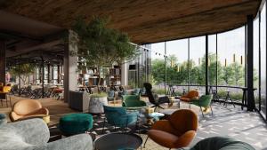 a lobby with chairs and tables and windows at Hotel Euro in Pardubice