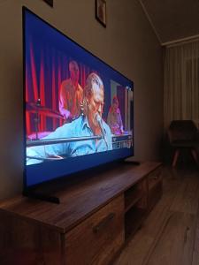 a large flat screen tv sitting on a wooden stand at Wind in Šilutė