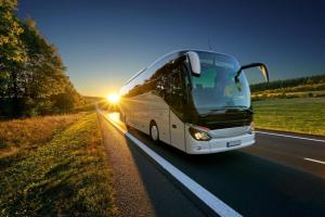a bus driving down a road with the sun setting at Hôtel de Charme By Arts & Millésimes in Essoyes