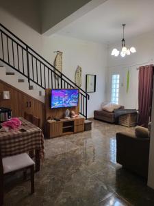 a living room with a tv and a staircase at Lamar home in Jakarta