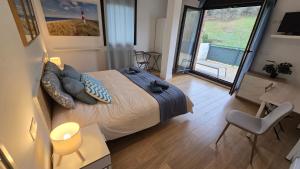 a bedroom with a king sized bed and a balcony at Laga Blue Surf in Ibarrangelu