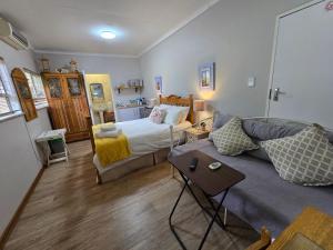 a living room with a bed and a couch at Modern rustic private flat in Bloemfontein