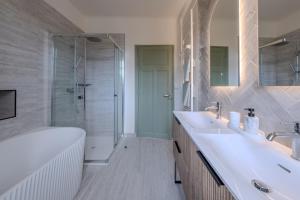 a bathroom with a tub and two sinks and a shower at La Villa des Coccinelles in Olivet +29 photos