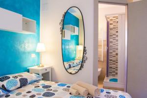 a bedroom with a mirror and a bed at Rosemary Charming Rooms in Termoli