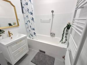 a white bathroom with a tub and a sink at Villa Hortensia in Aszófő