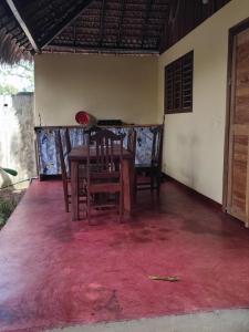 a table and chairs in a room with a red carpet at Chez Rosa in Nosy Be