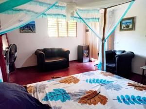 a bedroom with a bed with a comforter with leaves on it at Chez Rosa in Nosy Be
