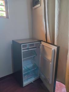 a small refrigerator with its door open in a kitchen at Chez Rosa in Nosy Be