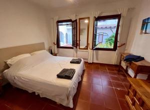 a bedroom with a white bed and two windows at Casa Cristalina Menorca in Fornells