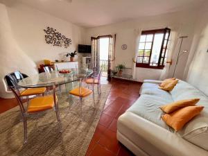 a living room with a glass table and a couch at Casa Cristalina Menorca in Fornells