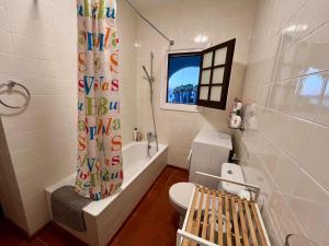 a bathroom with a toilet and a shower curtain at Casa Cristalina Menorca in Fornells +25 photos