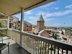 a balcony with a view of a church tower at Boutique Hotel Meidan View in Tbilisi City