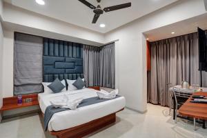 a bedroom with a large bed and a desk at Hotel Samarth Elite Baner - Indian Guests Only in Pune