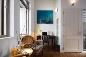 a living room with a door and a table and chairs at Non Inn The Post and Barber 3 Bedroom Riverside Shophouse with King and Twin Rooms in Bang Rak