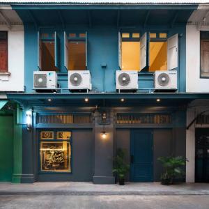 a building with speakers on the side of it at Non Inn The Post and Barber 3 Bedroom Riverside Shophouse with King and Twin Rooms in Bang Rak