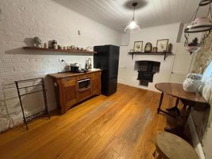 a kitchen with a black refrigerator and a wooden floor at Bathurst River House B & B in Bathurst