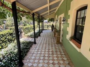 a walkway outside of a house with flowers at Bathurst River House B & B in Bathurst +28 photos