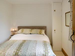a bedroom with a bed with a white comforter at Brandy's Barn in Middleham