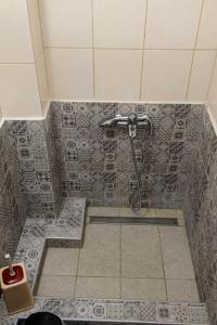 a shower in a bathroom with a tile floor at Hotel Makedonia in Évzonoi