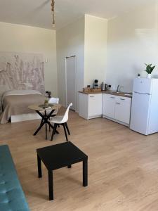 a kitchen and a living room with a table and a refrigerator at Villa Uma con Idromassaggio e Parcheggio Privato in Sannicandro Garganico