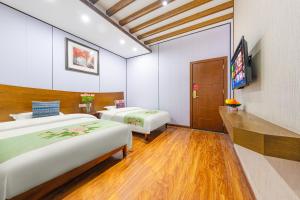 a hotel room with two beds and a television at A deer has you INN near by Tianmen Shan--Free pick-up-Aerial Cableway in Zhangjiajie