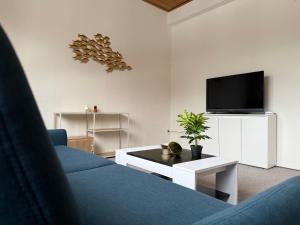 a living room with a blue couch and a tv at Bettina City Flat - Ground Floor in Werne an der Lippe