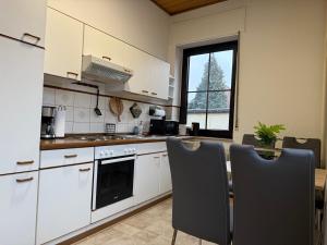 a kitchen with white cabinets and a table and chairs at Bettina City Flat - Ground Floor in Werne an der Lippe