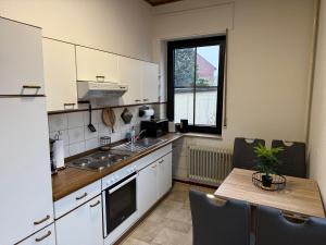 a kitchen with white cabinets and a table and a window at Bettina City Flat - Ground Floor in Werne an der Lippe +11 photos