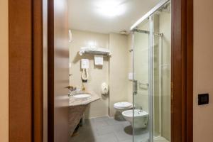 a bathroom with a toilet and a sink and a shower at Hotel Le Palme Lago Maggiore Bike Friendly in Dormelletto +85 photos