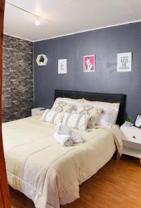 a bedroom with a large bed with a blue wall at Minidepto temuco in Temuco