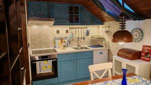 a small kitchen with blue cabinets and a sink at Apartman Pavle Mladenovac in Mladenovac