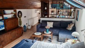 a living room with a blue couch and a table at Apartman Pavle Mladenovac in Mladenovac