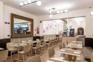 a restaurant with tables and chairs and a mirror at Hotel Le Palme Lago Maggiore Bike Friendly in Dormelletto