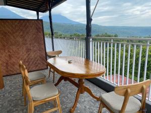 a table and chairs on a balcony with a view at Geriya Sena in Munduk +50 photos