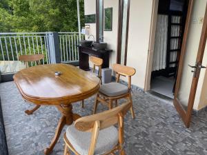 a wooden table and chairs on a porch at Geriya Sena in Munduk