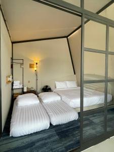 three beds in a room with glass walls at Homestay in Nhơn Trạch
