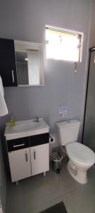 a bathroom with a toilet and a sink and a window at Studio Container Morano Calabro in Florianópolis +6 photos