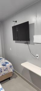 a white room with a tv on the wall at Studio Container Morano Calabro in Florianópolis